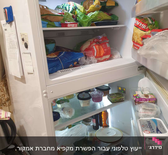 מקרר פתוח עם מדפים מלאים במזון ואריזות שונות